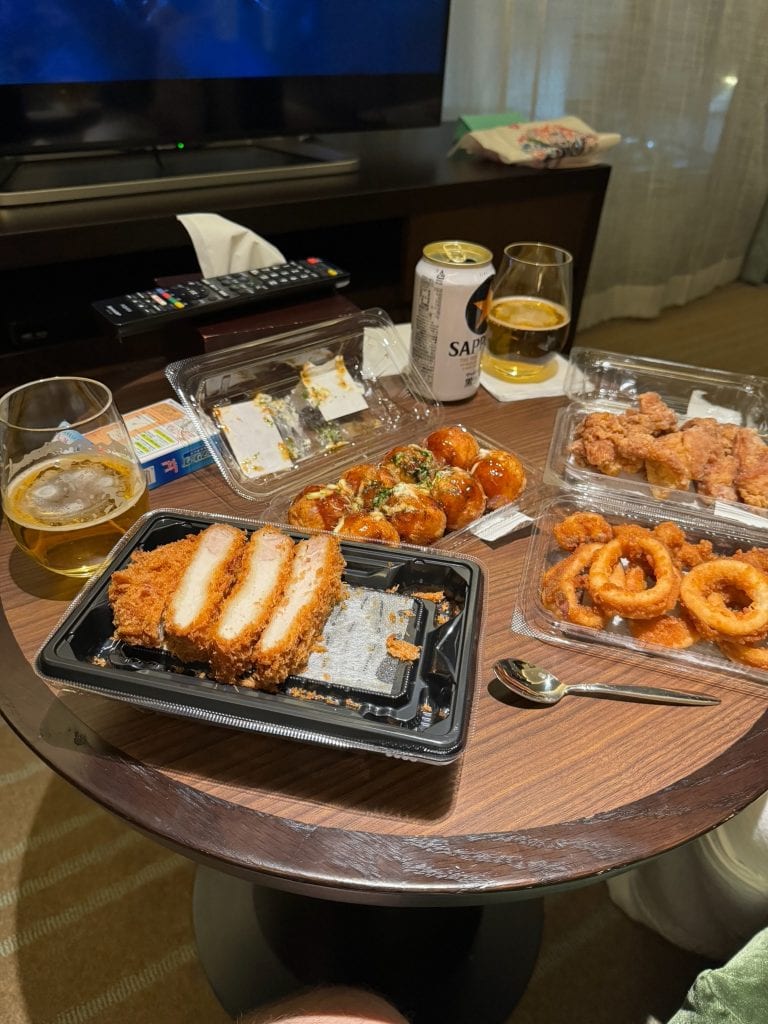 Convenience store dinner and beer laid out in hotel room