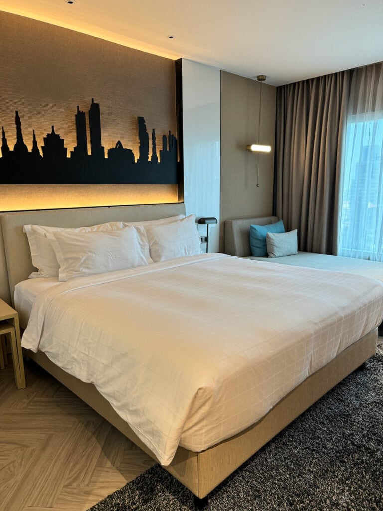 King bed with skyline headboard and daybed in Grand Deluxe King Room at Pathumwan Princess Hotel Bangkok