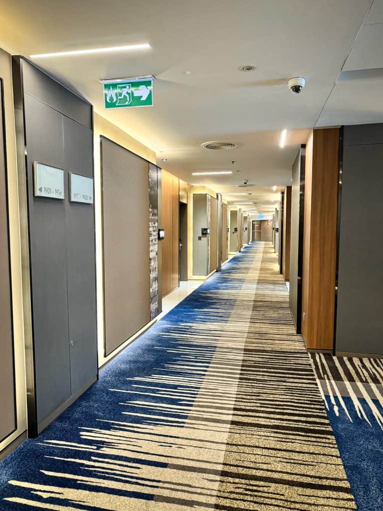 Modern hotel hallway at Pathumwan Princess Bangkok with abstract carpet design and warm lighting