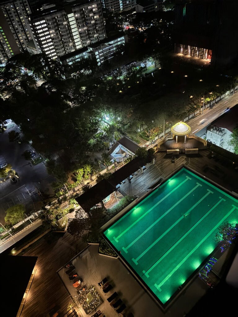 Night view of the pool at Pathumwan Princess Hotel Bangkok with city lights in the background