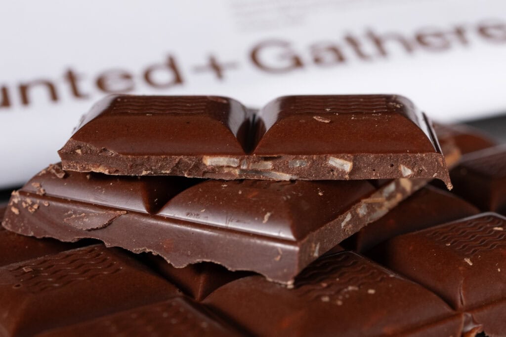 Close-up of Hunted + Gathered Milk Chocolate + Coconut 46% Cacao bar with visible coconut pieces in the chocolate.