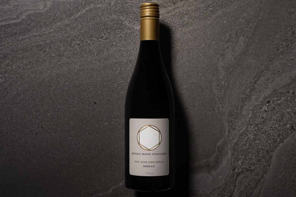 Honeymoon Vineyard Shiraz 2014 bottle photographed on a dark stone surface with soft side lighting.