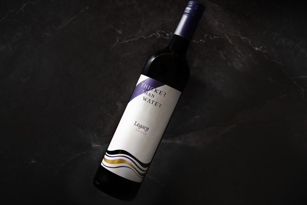 Bottle of Thicker Than Water Legacy Shiraz 2021 on dark marble background