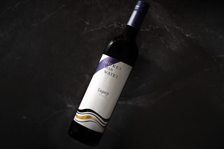 Bottle of Thicker Than Water Legacy Shiraz 2021 on dark marble background