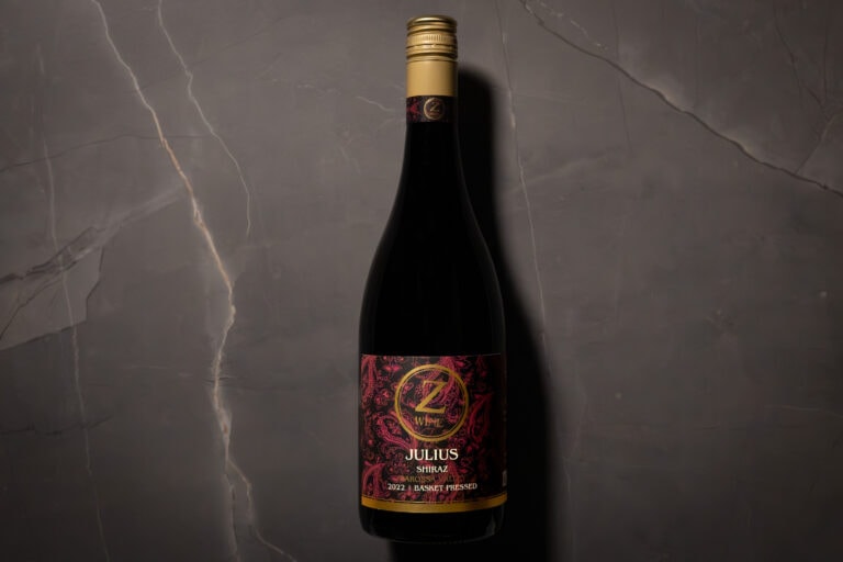 Z WINE Julius Shiraz 2022 bottle on dark marble surface – elegant lighting highlighting the gold screwcap and intricate maroon label