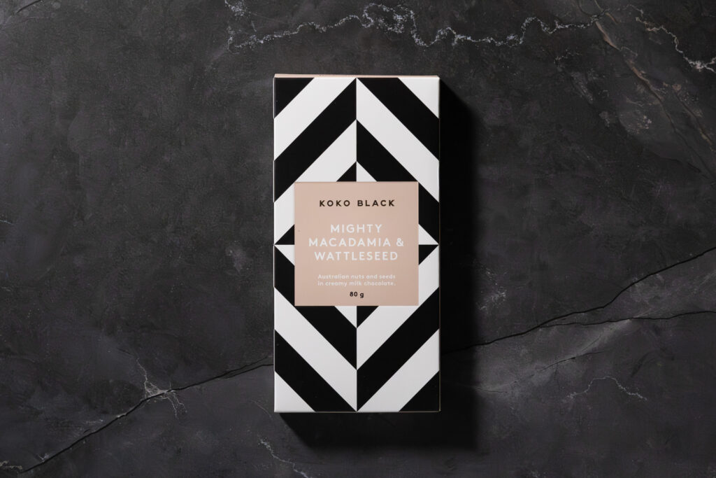 Mighty Macadamia and Wattleseed chocolate bar packaging photographed flat on dark background