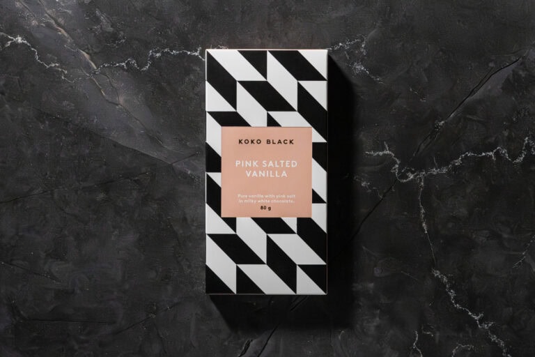 Koko Black Pink Salted Vanilla chocolate bar in its packaging on dark stone