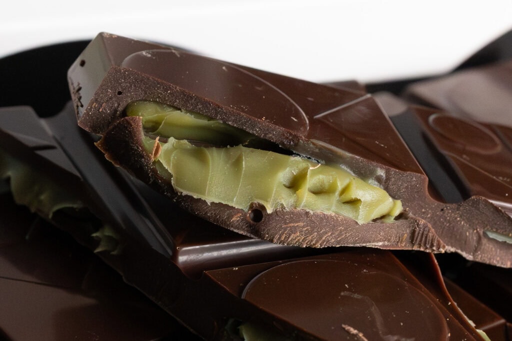 Close-up of pistachio ganache centre inside Koko Black dark chocolate bar