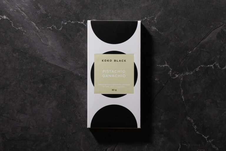 Koko Black Pistachio Ganachio chocolate bar in its packaging on dark stone