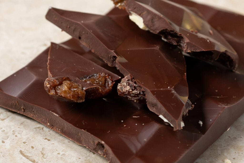Broken pieces of Zokoko Almond & Raisin 70% dark chocolate showing texture and inclusions