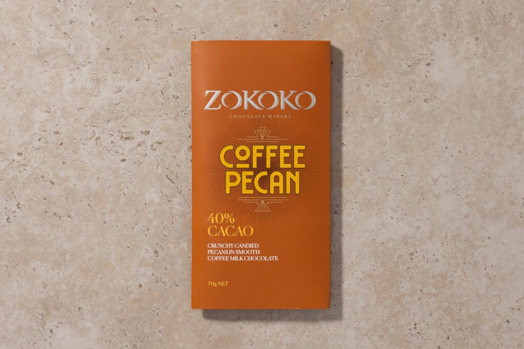 Zokoko Coffee Pecan milk chocolate in brown envelope-style packaging on stone