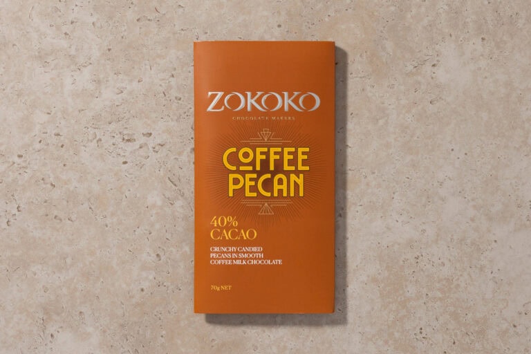 Zokoko Coffee Pecan milk chocolate in brown envelope-style packaging on stone