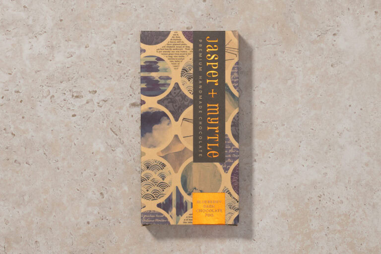 Jasper + Myrtle Blueberry Dark Chocolate 70g bar in patterned packaging on a stone surface