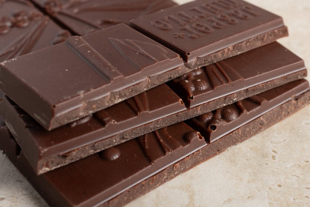 Stacked squares of Jasper + Myrtle Blueberry Dark Chocolate showing thickness and texture