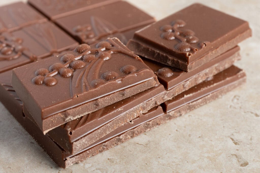 Close-up of Jasper + Myrtle Classic Milk Chocolate 46% pieces stacked and broken to show texture