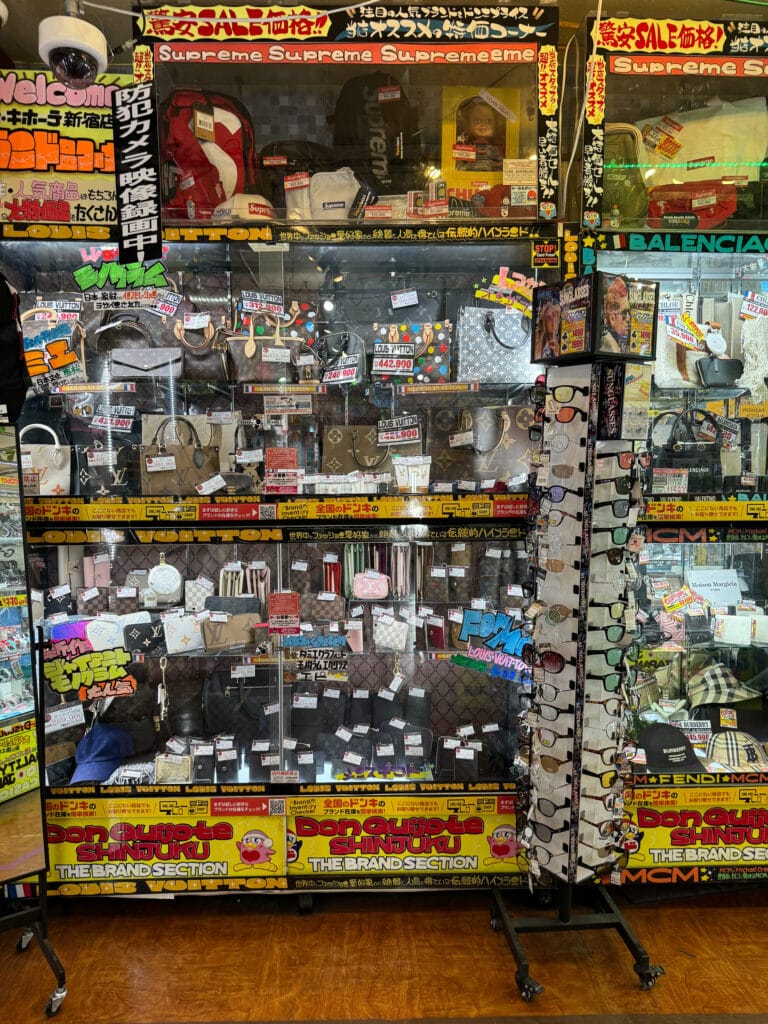 Second-hand luxury bags displayed in a glass cabinet inside a Donki store in Tokyo