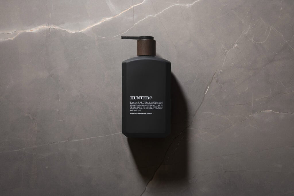 Hunter Lab Hand & Body Wash matte black pump bottle photographed against a grey stone background