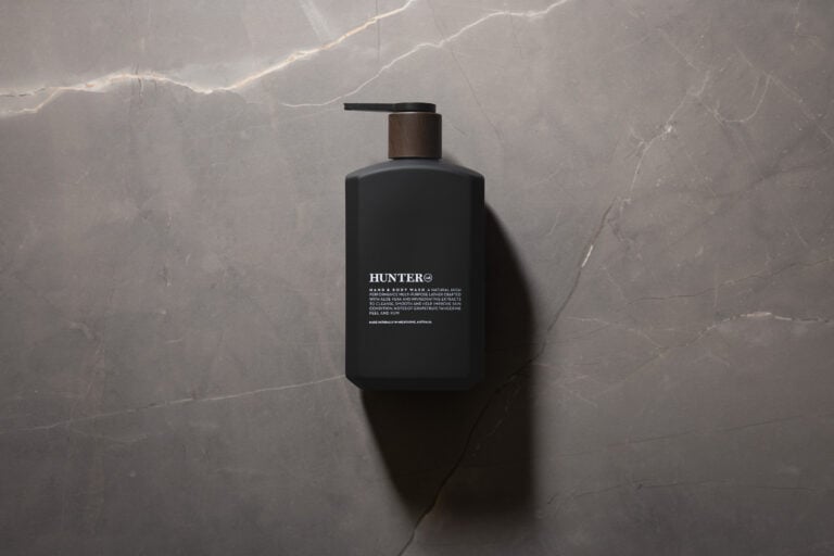 Hunter Lab Hand & Body Wash matte black pump bottle photographed against a grey stone background