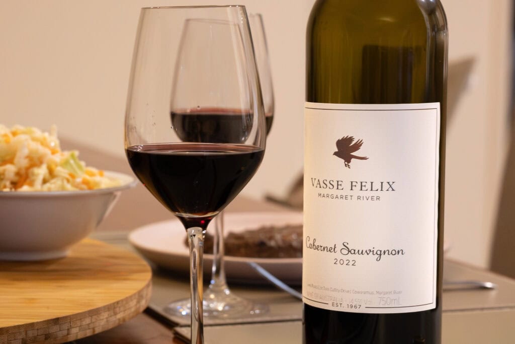 Glass and bottle of Vasse Felix Margaret River Cabernet Sauvignon 2022 served with steak, sweet potato fries and coleslaw.