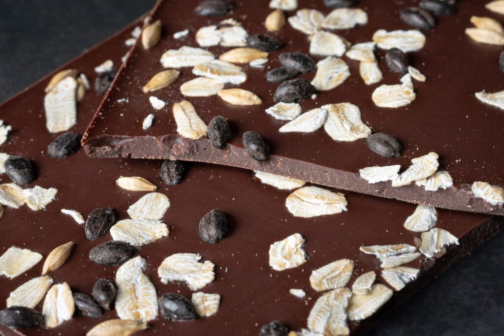Close-up of Ratio The Beer Bar 63% dark chocolate showing rolled oats, malted barley and chocolate thickness.